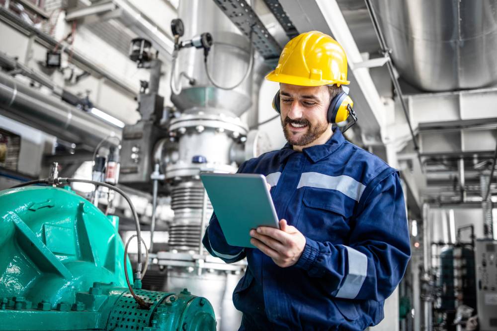 retrain as a gas engineer - man holding clipboard in hard hat on an industrial site