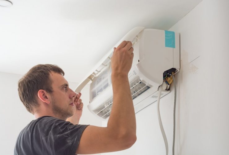 man installing an air con unit on the wall - fgas regulation