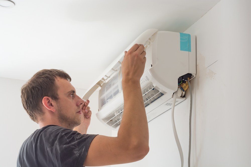 man installing an air con unit on the wall - fgas regulation