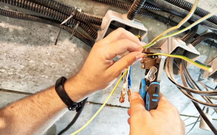 mans hands working on wiring and electrical engineering as his career
