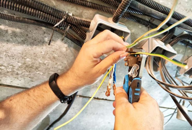 mans hands working on wiring and electrical engineering as his career