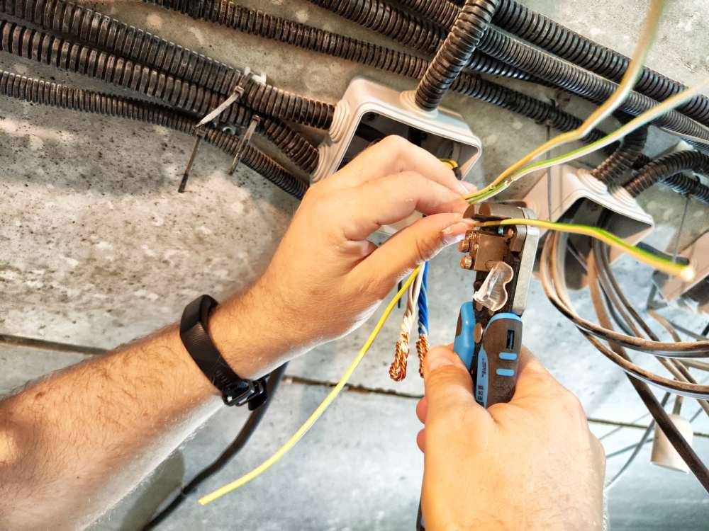 mans hands working on wiring and electrical engineering as his career