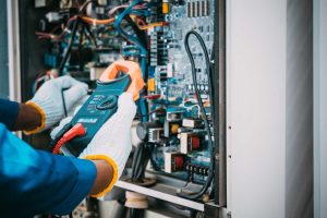 Refrigeration engineer testing electrics