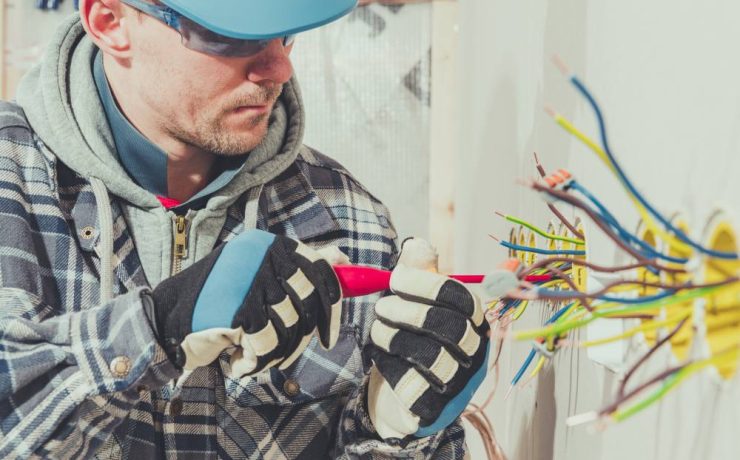 man working on electrical wiring wearing protective glasses- electrical safety tips