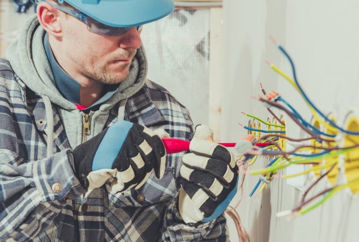 man working on electrical wiring wearing protective glasses- electrical safety tips